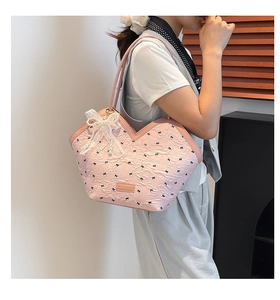 Close-up of pink tote bag with bow print and exquisite pearl lace bow pendant detail