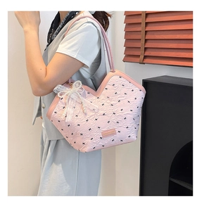 Pink tote bag detail with black bow patterns, lace ribbon, and pearl charm decoration