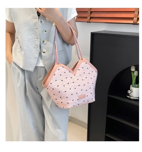 Detailed close-up of pink shoulder bag with bow embroidery and unique pleated texture
