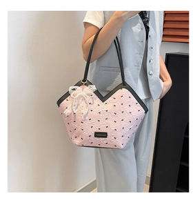 Close-up of pink bucket bag with black bow floral print and lace pearl charm detail
