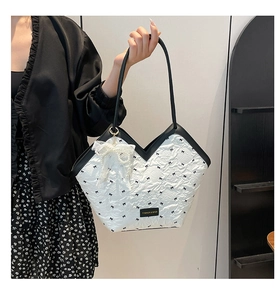 Detail of white quilted tote bag with black bow print and lace pearl pendant