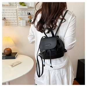 Vista modella di mini zaino nero in pelle PU con chiusura a coulisse e patta