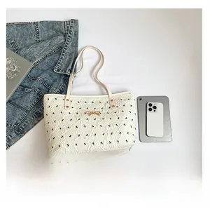 Flat lay of cream quilted tote bag with golden bow hardware and casual lifestyle items