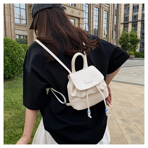 Detail of off-white mini backpack featuring beaded drawstring and PAUTON metal logo
