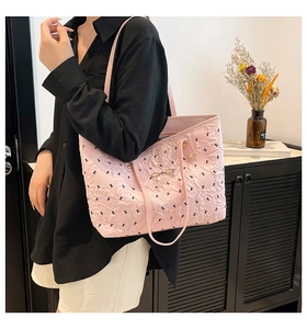 Detail of pink quilted tote bag with letter K embroidery and delicate metal bow accent