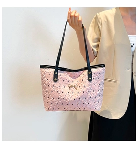 Close-up of pink tote bag with gold bow ornament and black cat silhouette pattern