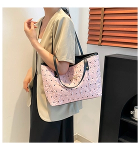 Detail of pink quilted tote bag with golden bow and black shoulder straps on a model