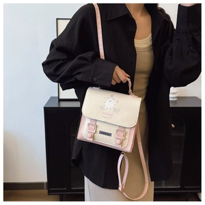Détail d'un sac bandoulière beige et rose avec chat de dessin animé et sangle réglable