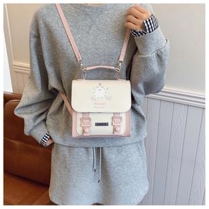 Détail d'un petit sac à dos blanc et rose avec motif ours et sangles de fermeture doubles