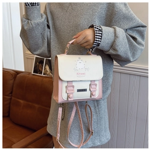 Detailansicht der pink-weißen PU-Handtasche mit Cartoon-Tiermotiv und Metall-Emblem