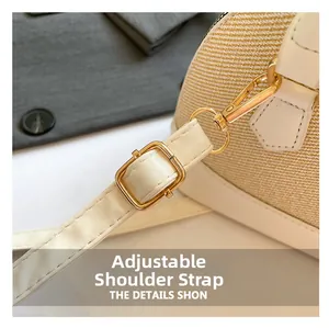 Close-up of adjustable white leather shoulder strap and golden metal hooks on a straw bag