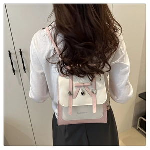 Detail view of pink and beige mini backpack with bow decoration worn by a model