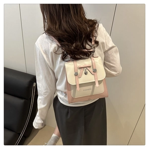 Mannequin portant un mini sac à dos rose et crème avec nœud et pendentif cœur