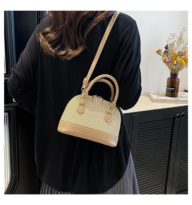 Close-up of beige shell bag with woven texture and premium synthetic leather stitching