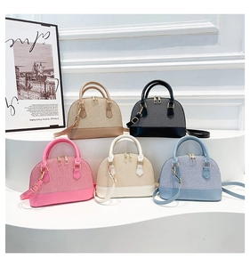 Detail of shell-shaped bags in five colors with woven texture and gold zippers