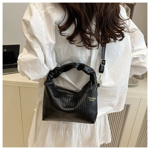 Detail of black pleated PU leather bag featuring soft cloud handle and golden hardware