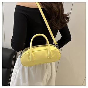 Minimalist lemon yellow bowling bag with top handles and adjustable shoulder strap