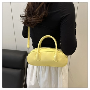 Pale yellow baguette bag shown worn crossbody on model to demonstrate size and fit