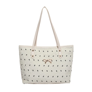 Chic cream tote bag with black bow print and gold metal bow detail for women