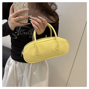 Glossy yellow baguette bag with slim handles shown in a minimal mirror selfie shot