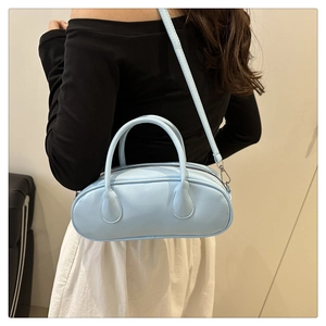 Detail of light blue minimalist pillow bag with smooth faux leather and top handles