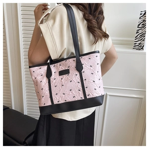 Model wearing large pink tote bag with black bow print and pleated texture detail