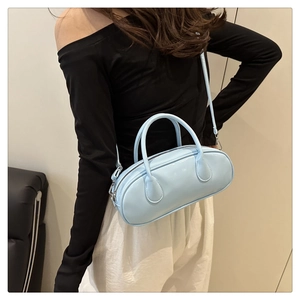 Detail of light blue patent leather bowling bag with shiny finish and silver zipper
