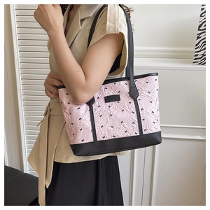 Detailed close-up of pink tote bag with black bow patterns and pleated fabric texture