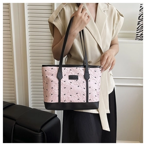 Detail of pink tote bag with bow prints featuring leather straps and Creative Cat label