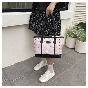 Detail of pink pleated tote bag with black bow embroidery and Creative Cat logo