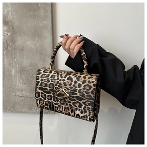 Close-up of leopard print crossbody bag with elegant golden bow metal hardware detail