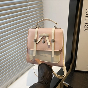 Pink and beige dual-tone bow backpack with heart pendant and fashion text detail