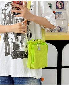 Detail of neon green mini nylon crossbody bag with adjustable yellow shoulder strap