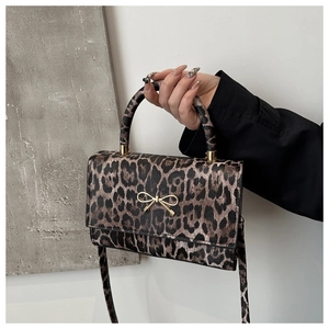 Details der Leopard-Handtasche mit goldener Schleifenschnalle und hochwertiger Lederstruktur