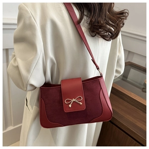 Detail of red vintage shoulder bag with matte leather and golden bow metal clasp