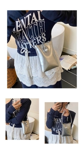 Close-up of a silver crossbody phone bag with a large pearl buckle and thin strap