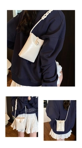 Detail of white glossy mini phone bag featuring a large pearl button and braided strap