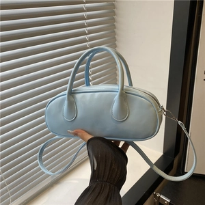 Light blue faux leather baguette bag with dual handles and adjustable shoulder strap