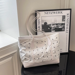 Large white pleated tote bag with black bow print and shoulder straps for daily commute
