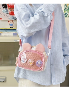 Detailed view of pink mesh rabbit ear bag with cute badges and adjustable strap
