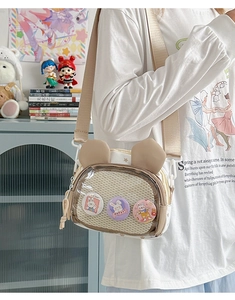 Detail of cute bunny ear crossbody bag with transparent pocket and decorative badges
