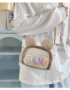 Detail of cute rabbit ear ita bag featuring transparent window with cartoon badges