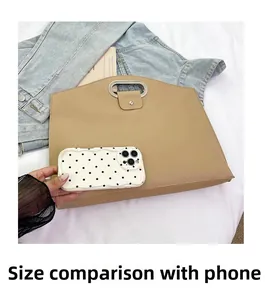 Comparaison de taille du sac de bureau avec un téléphone montrant la capacité et le cuir