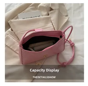 Pink crocodile-embossed underarm bag showing interior capacity with phone and card holder