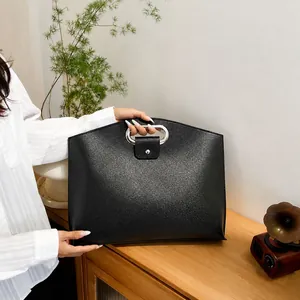 Detail of black leather business briefcase with silver metal handle and snap closure