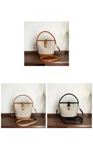 Detail of hand-woven straw bucket bag with leather trim and gold metal buckle hardware