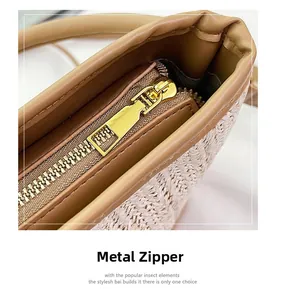 Detailed view of the smooth gold metal zipper and premium woven straw bag texture