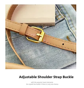 Detail of brown leather strap with golden buckle adjustment for straw bucket bag