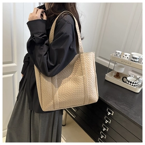 Detailed view of apricot woven tote bag with square texture on synthetic leather