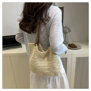 Détail du sac fourre-tout tissé montrant la texture crochetée blanche et la anse en cuir